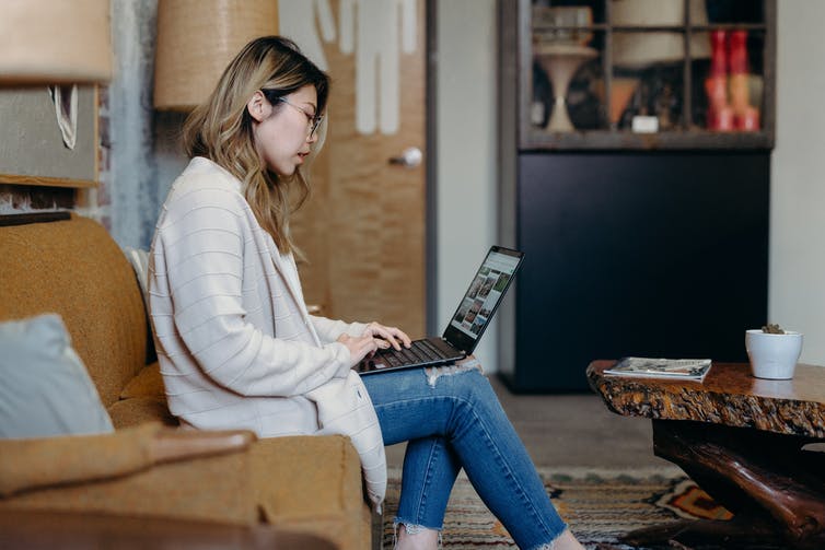 A young woman is on her laptop at home.