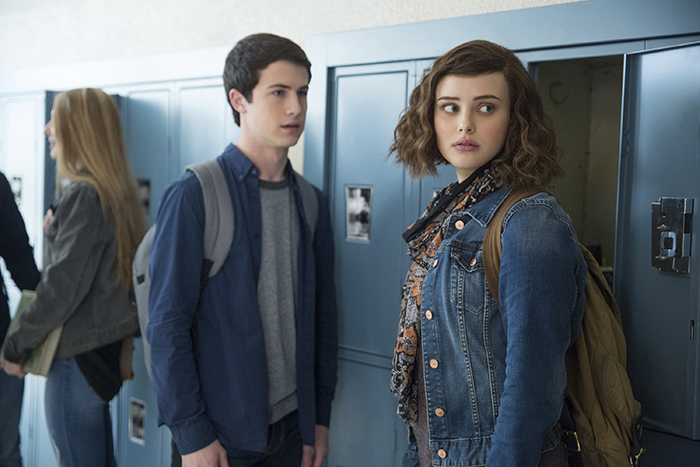 Two characters from Netflix program in front of school lockers.