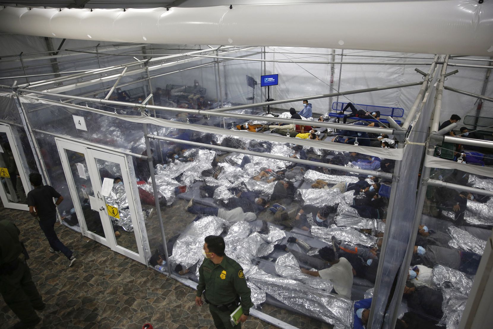 FILE - In this March 30, 2021, file photo, young minors lie inside a pod at the Donna Department of Homeland Security holding facility, the main detention center for unaccompanied children in the Rio Grande Valley run by U.S. Customs and Border Protection (CBP), in Donna, Texas. U.S. officials are scrambling to handle a dramatic spike in children crossing the U.S.-Mexico border alone. It's lead to a massive expansion in emergency facilities to house them as more kids arrive than can be released to close relatives in the United States. (AP Photo/Dario Lopez-Mills, Pool, File)