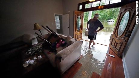 In Slidell, Louisiana, Danny Gonzales walks in his flooded house as water recedes Saturday.
