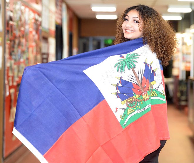 Jolisa Zenny Pettiford, seen here on Friday, May 28, 2021 wrapped in the Haitian flag, said drawing on her Haitian heritage has helped her during difficult times.